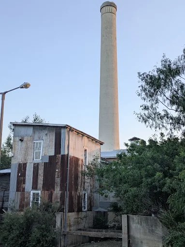The Old Hidalgo Pumphouse is a two story structure with an attached tower that is more than twice the height of the pumphouse. The outside of the building is sheathed in corrugated iron, much of it rusted. The pumphouse has windows on both levels.