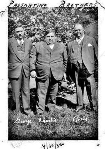 Black and white portrait of the three Passantino brothers George, Charlie, and Rosie taken in 1932. They are standing outside wearing 3-piece suits.